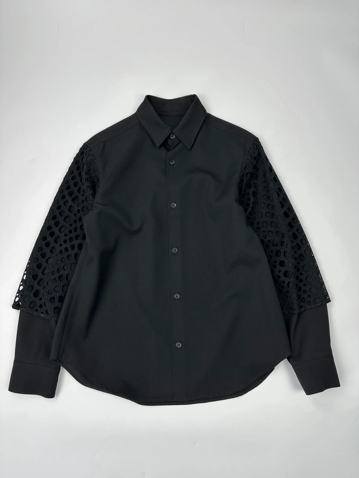 Y's by Yohji Yamamoto black shirt with mesh sleeves and subtle logo details.