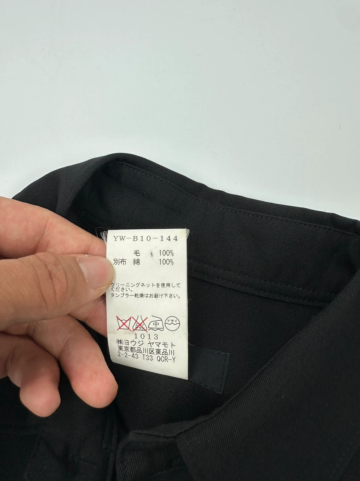 Y's by Yohji Yamamoto black shirt with mesh sleeves and subtle logo details.