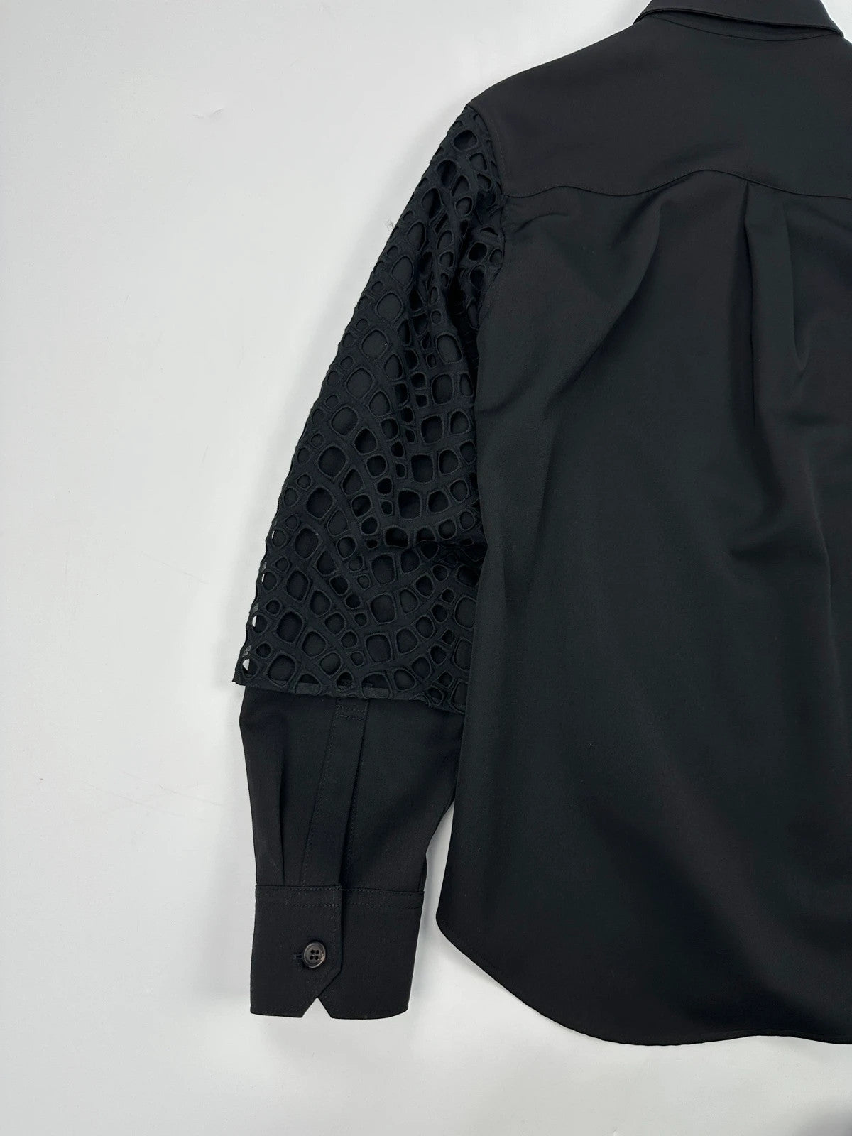 Y's by Yohji Yamamoto black shirt with mesh sleeves and subtle logo details.