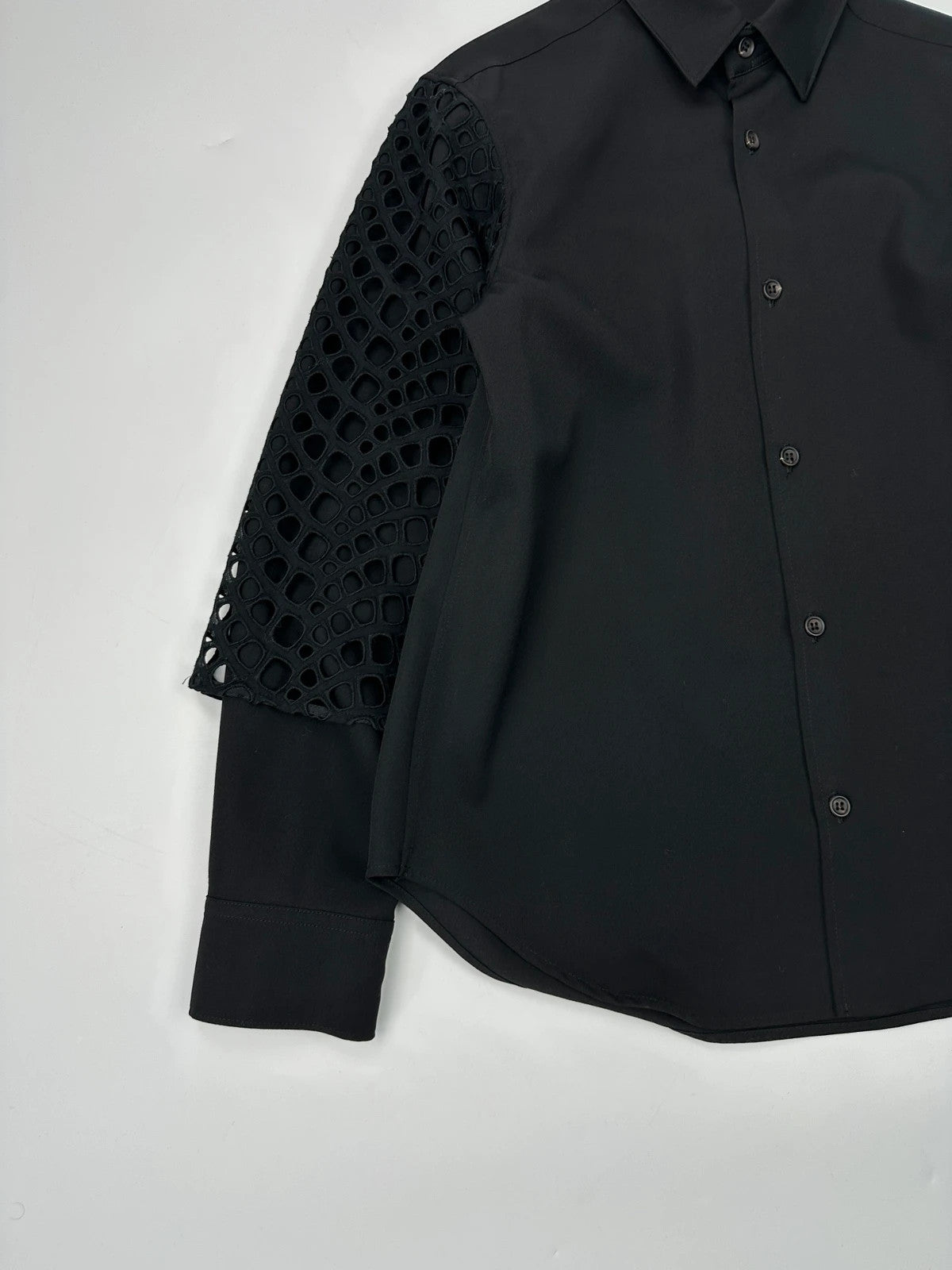 Y's by Yohji Yamamoto black shirt with mesh sleeves and subtle logo details.