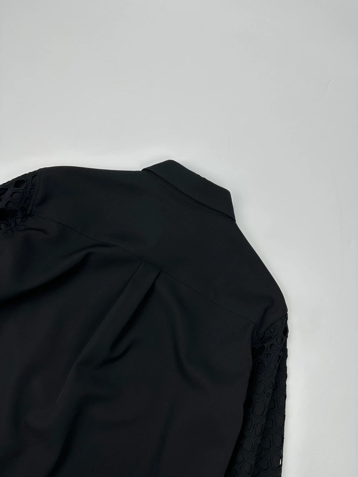 Y's by Yohji Yamamoto black shirt with mesh sleeves and subtle logo details.