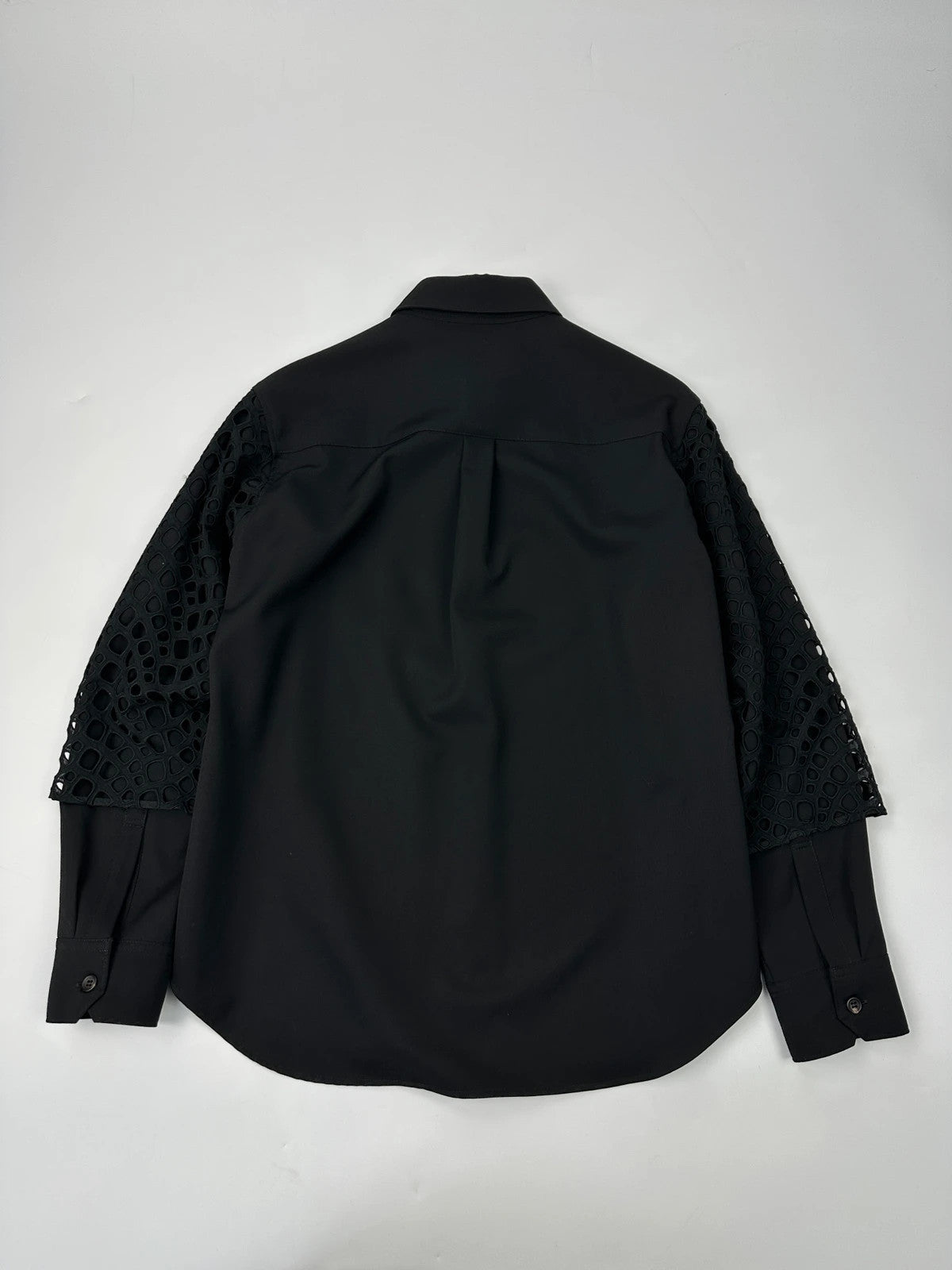 Y's by Yohji Yamamoto black shirt with mesh sleeves and subtle logo details.