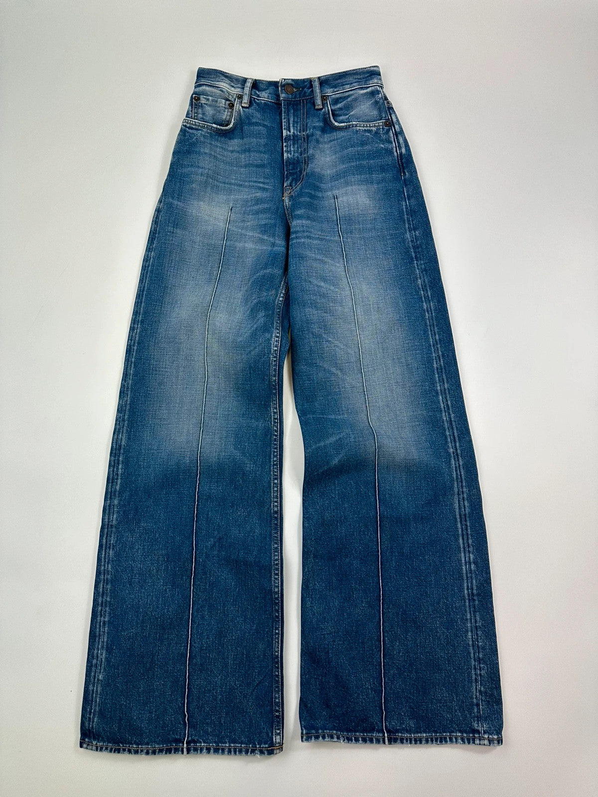 Acne Studios blue wide leg denim pants with subtle logo detailing and vintage style.