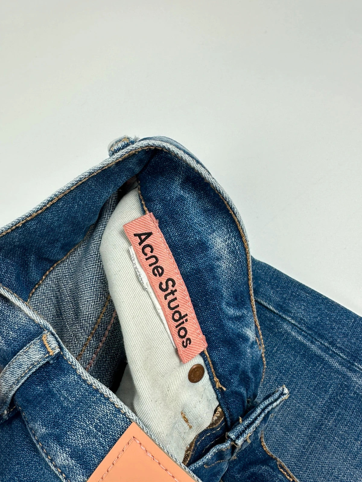 Acne Studios blue wide leg denim pants with subtle logo detailing and vintage style.
