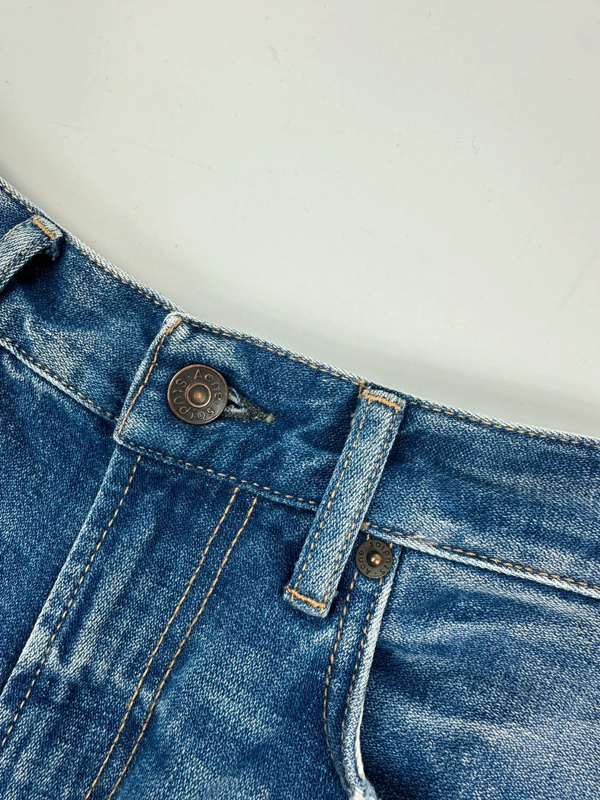 Acne Studios blue wide leg denim pants with subtle logo detailing and vintage style.