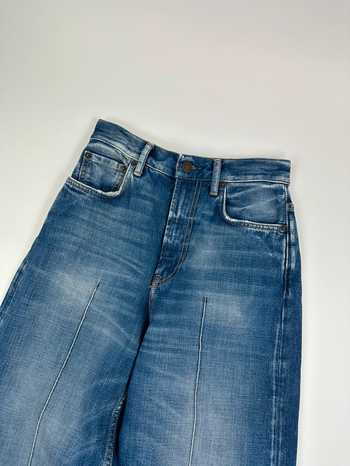 Acne Studios blue wide leg denim pants with subtle logo detailing and vintage style.
