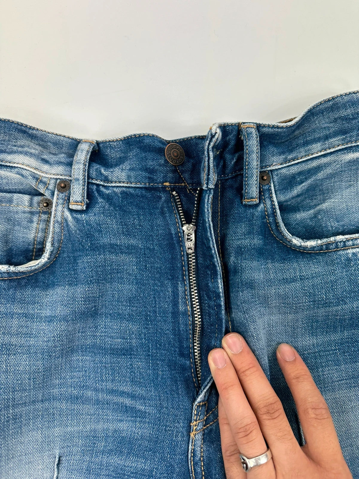 Acne Studios blue wide leg denim pants with subtle logo detailing and vintage style.