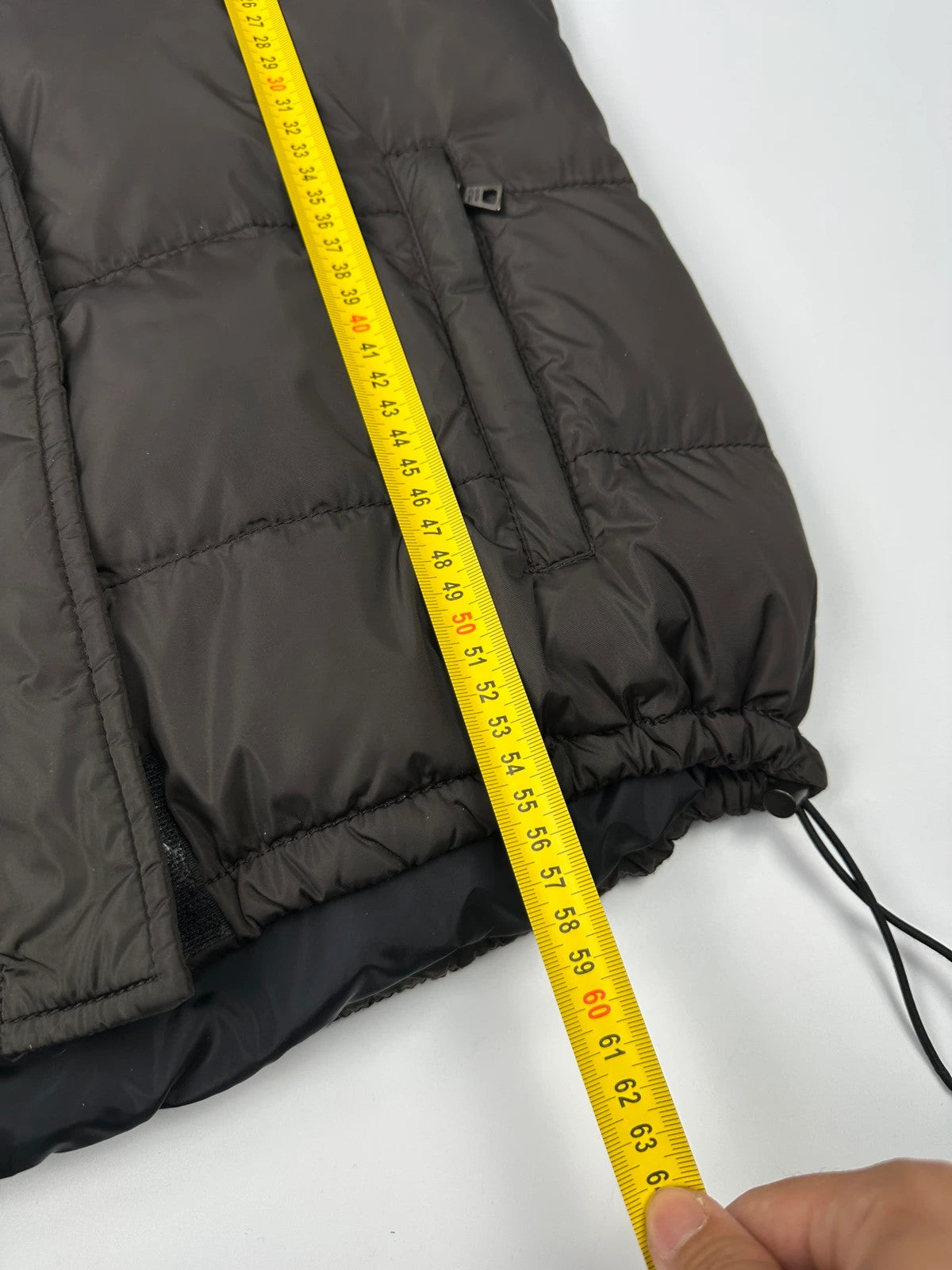 Prada brown puffer vest with retractable hood and linearossa logo details.