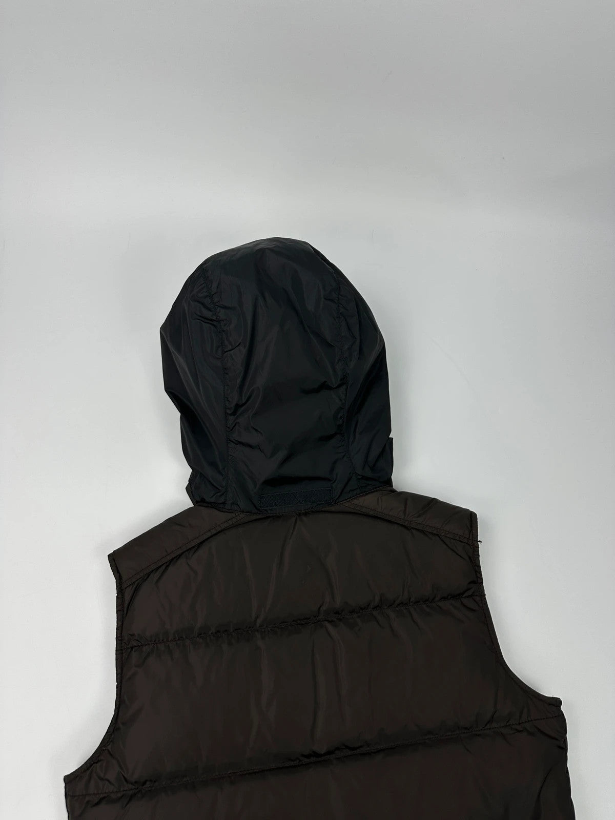 Prada brown puffer vest with retractable hood and linearossa logo details.