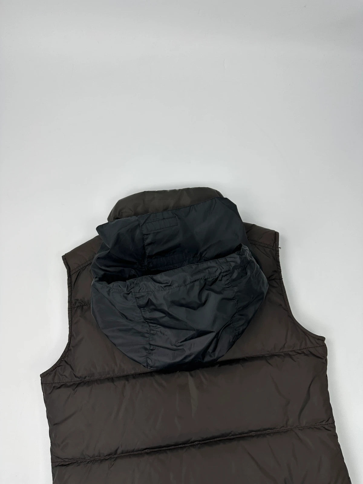 Prada brown puffer vest with retractable hood and linearossa logo details.