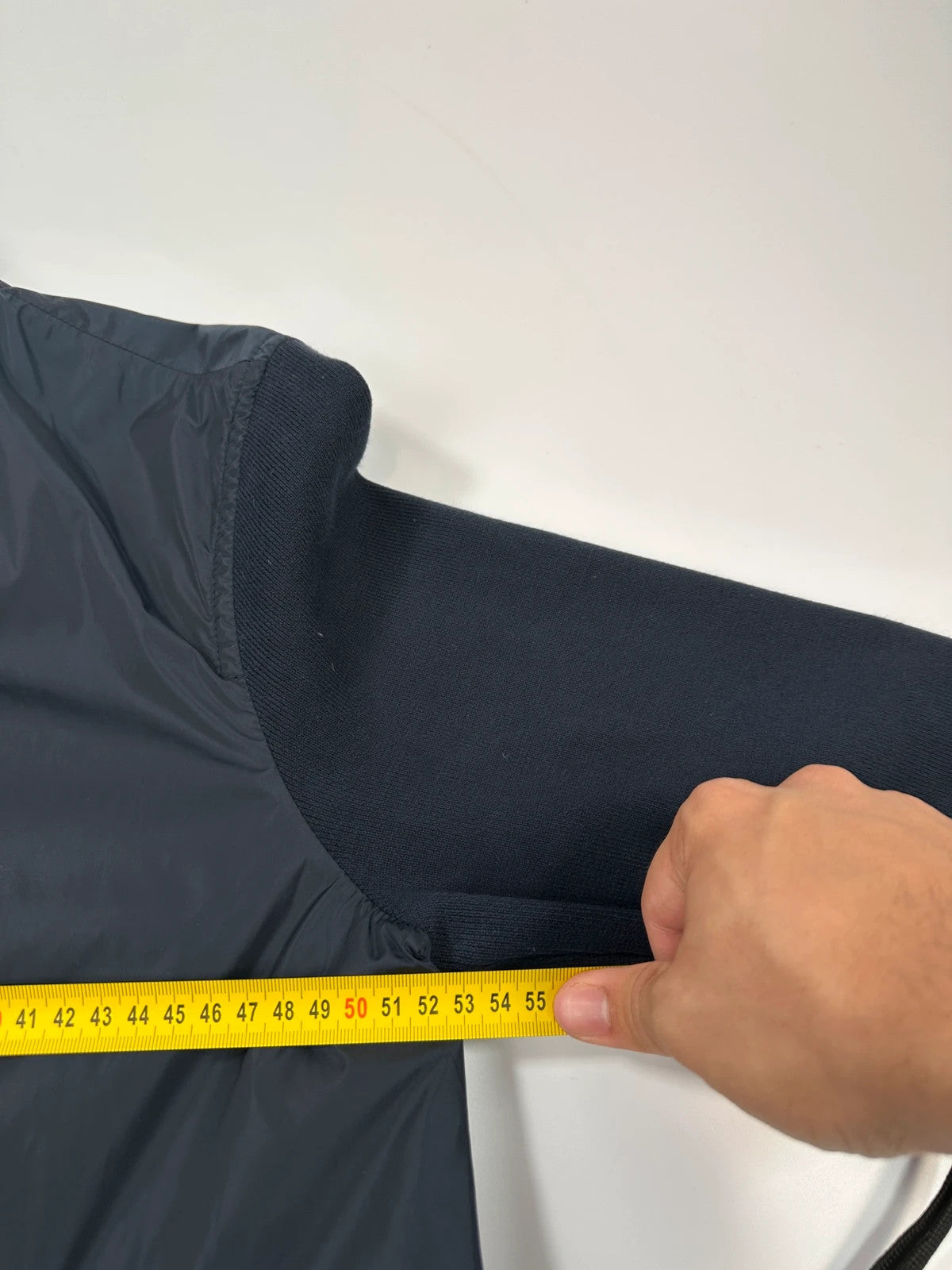 Prada navy blue hybrid jacket with nylon front and cotton sleeves, minimalist design.