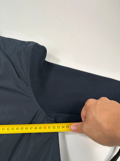 Prada navy blue hybrid jacket with nylon front and cotton sleeves, minimalist design.
