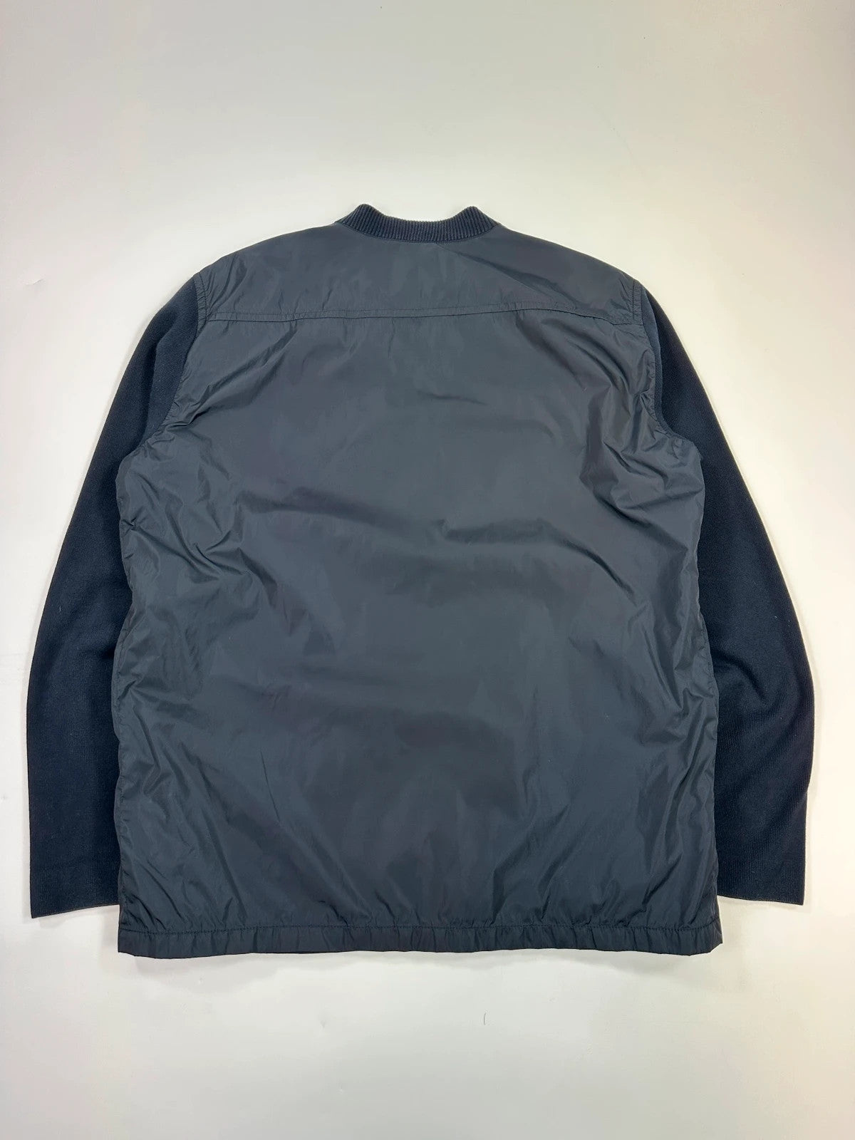Prada navy blue hybrid jacket with nylon front and cotton sleeves, minimalist design.