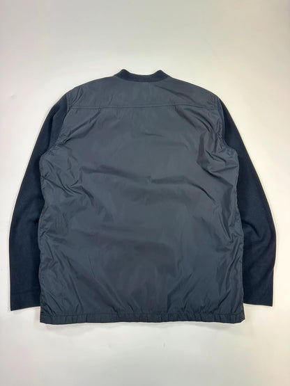 Prada navy blue hybrid jacket with nylon front and cotton sleeves, minimalist design.