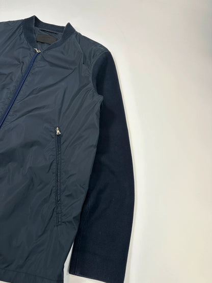 Prada navy blue hybrid jacket with nylon front and cotton sleeves, minimalist design.