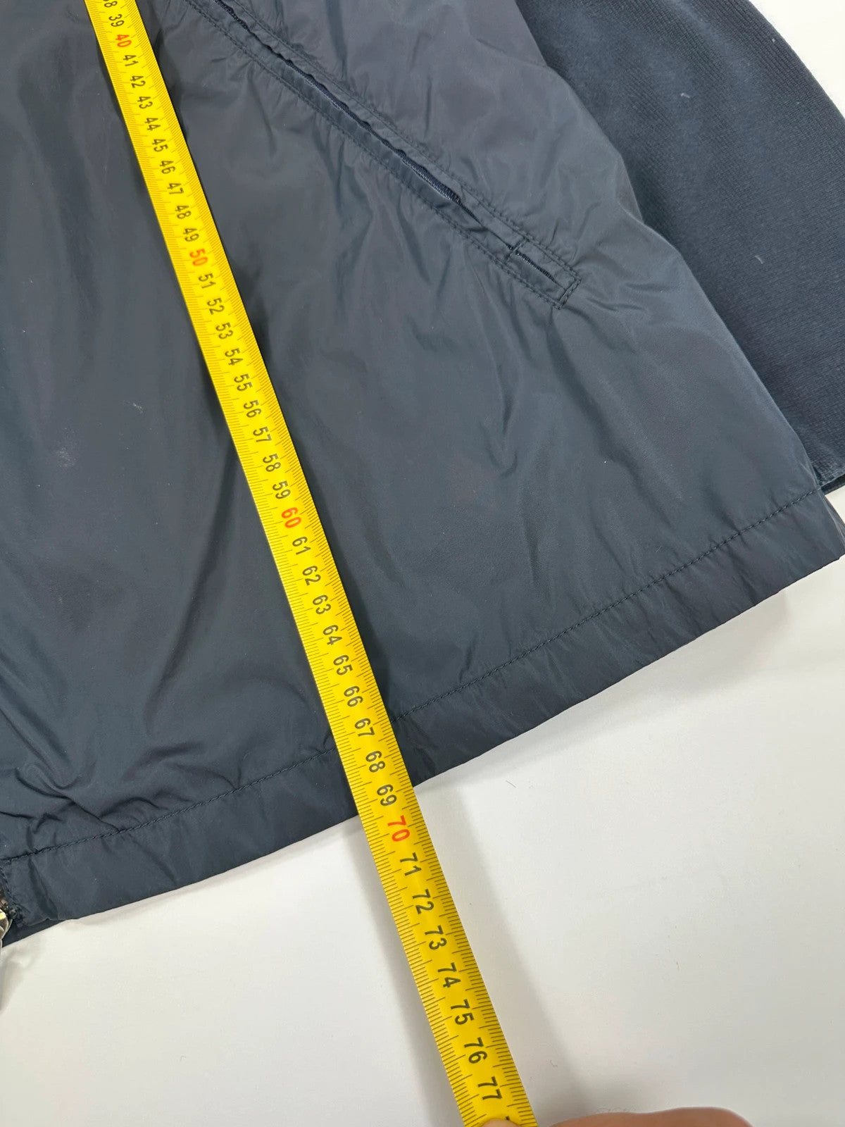 Prada navy blue hybrid jacket with nylon front and cotton sleeves, minimalist design.