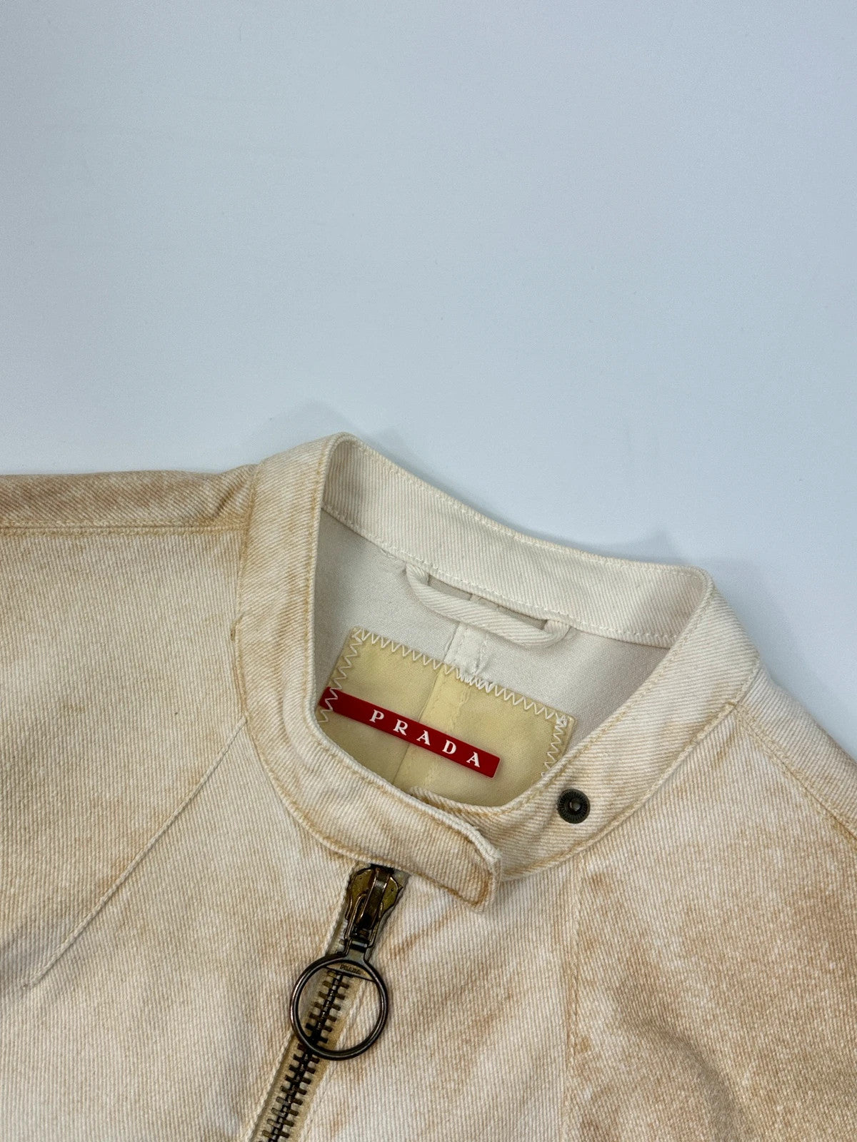 Prada brown and white denim jacket with lace detailing and faded wash effect.