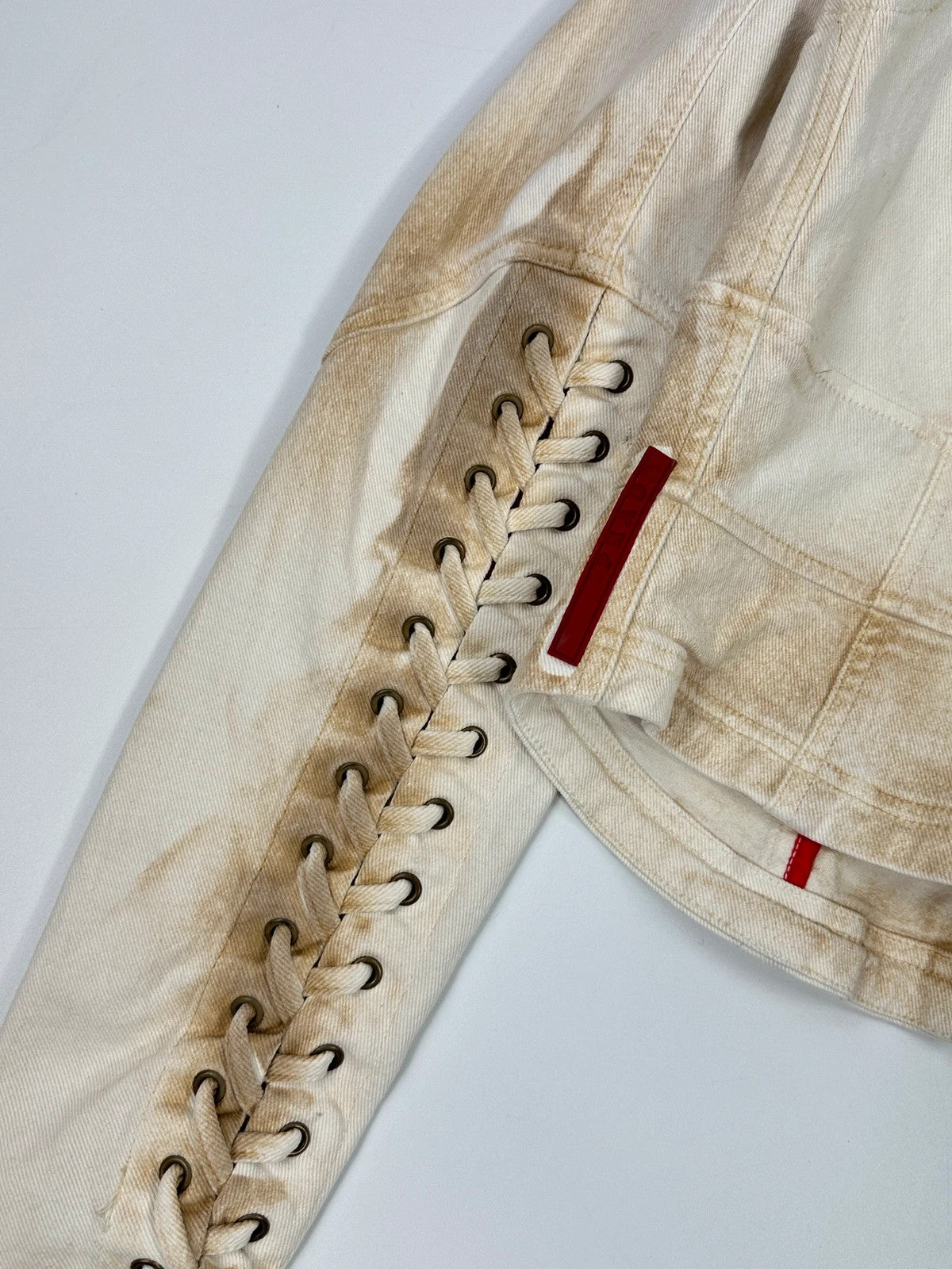 Prada brown and white denim jacket with lace detailing and faded wash effect.