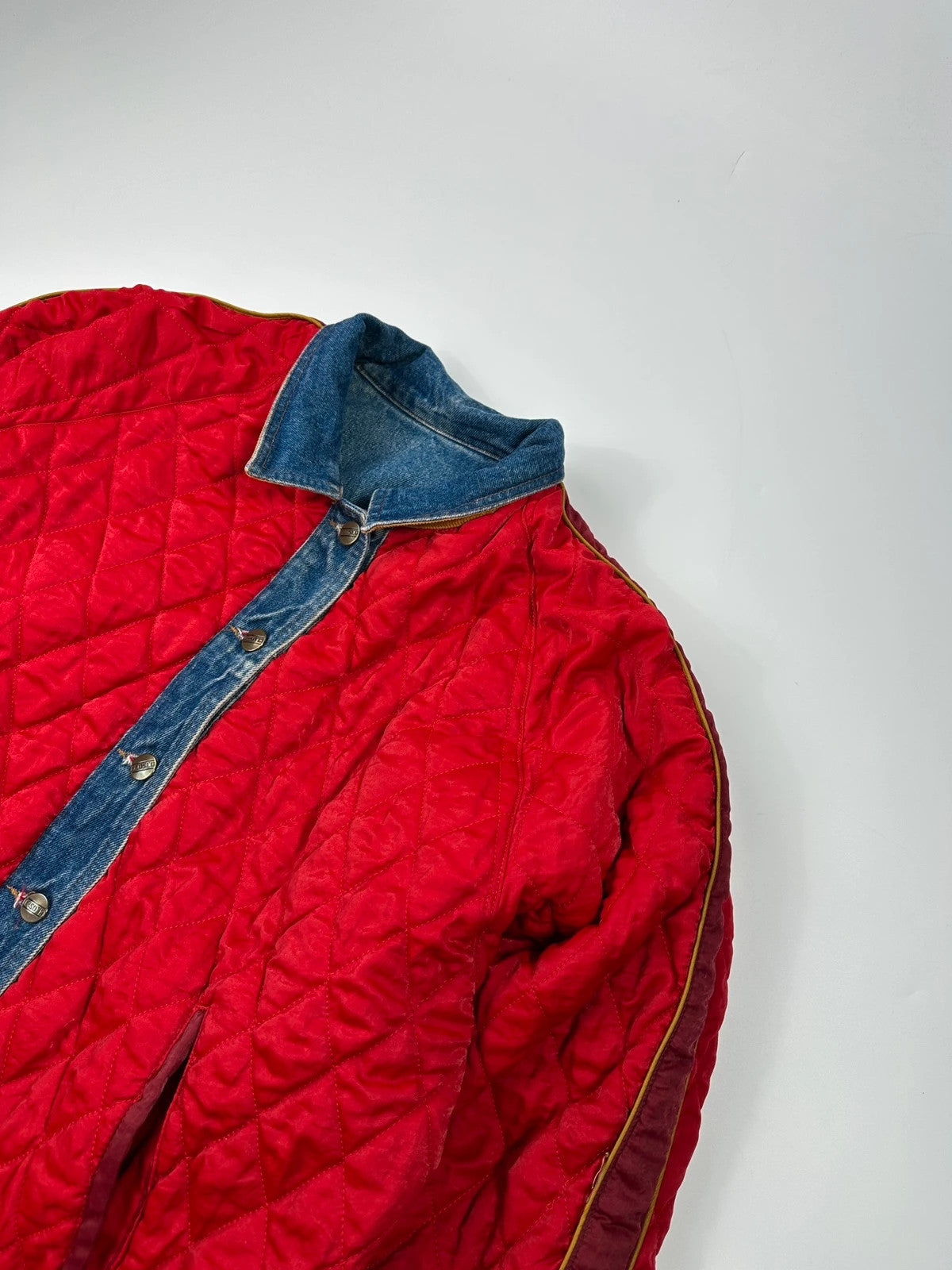 Marithé François Girbaud blue and red reversible denim bomber jacket with logo details.