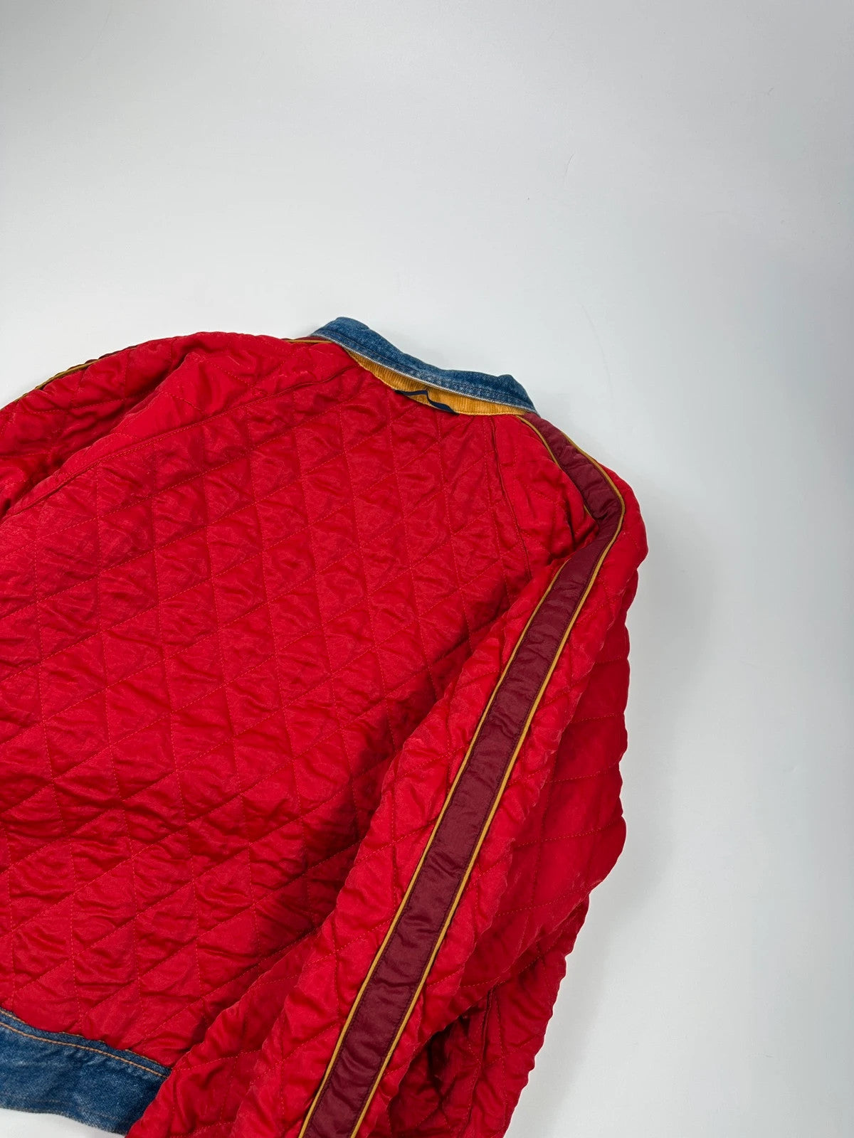 Marithé François Girbaud blue and red reversible denim bomber jacket with logo details.