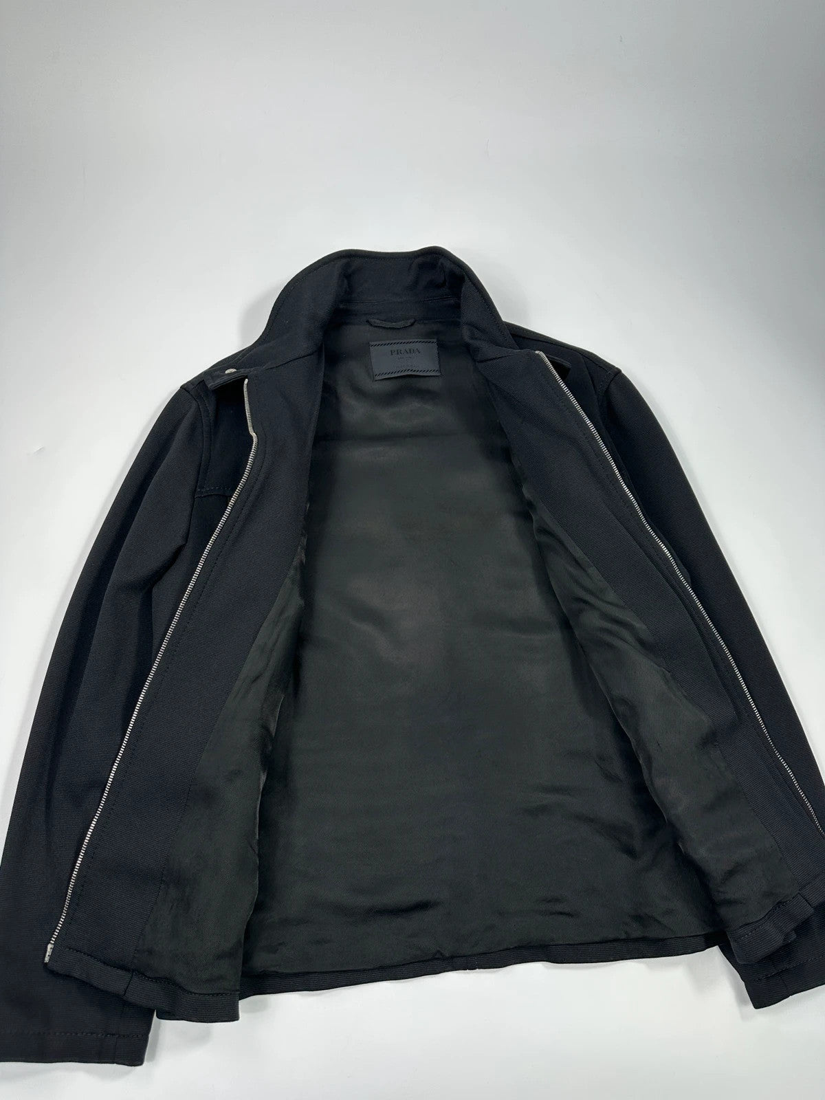 Prada black nylon Harrington bomber jacket with padded lining and vintage logo details.