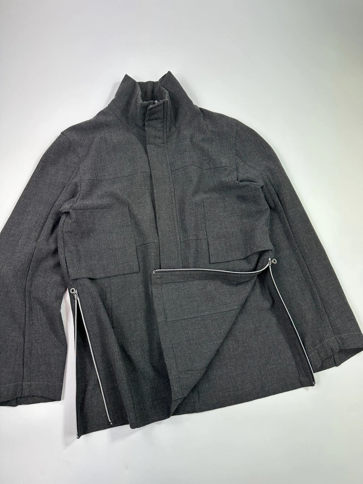 Marithé François Girbaud grey tech jacket with side zippers and minimalist design.