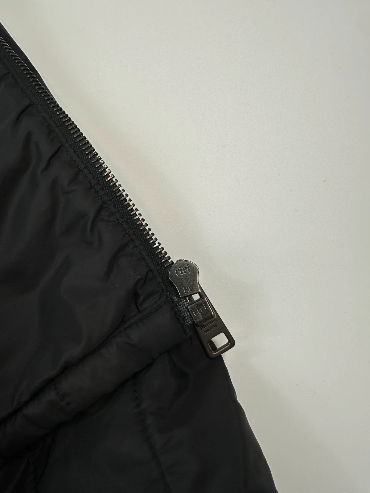 Prada black padded quilted nylon jacket with ribbed side panels and logo detailing.