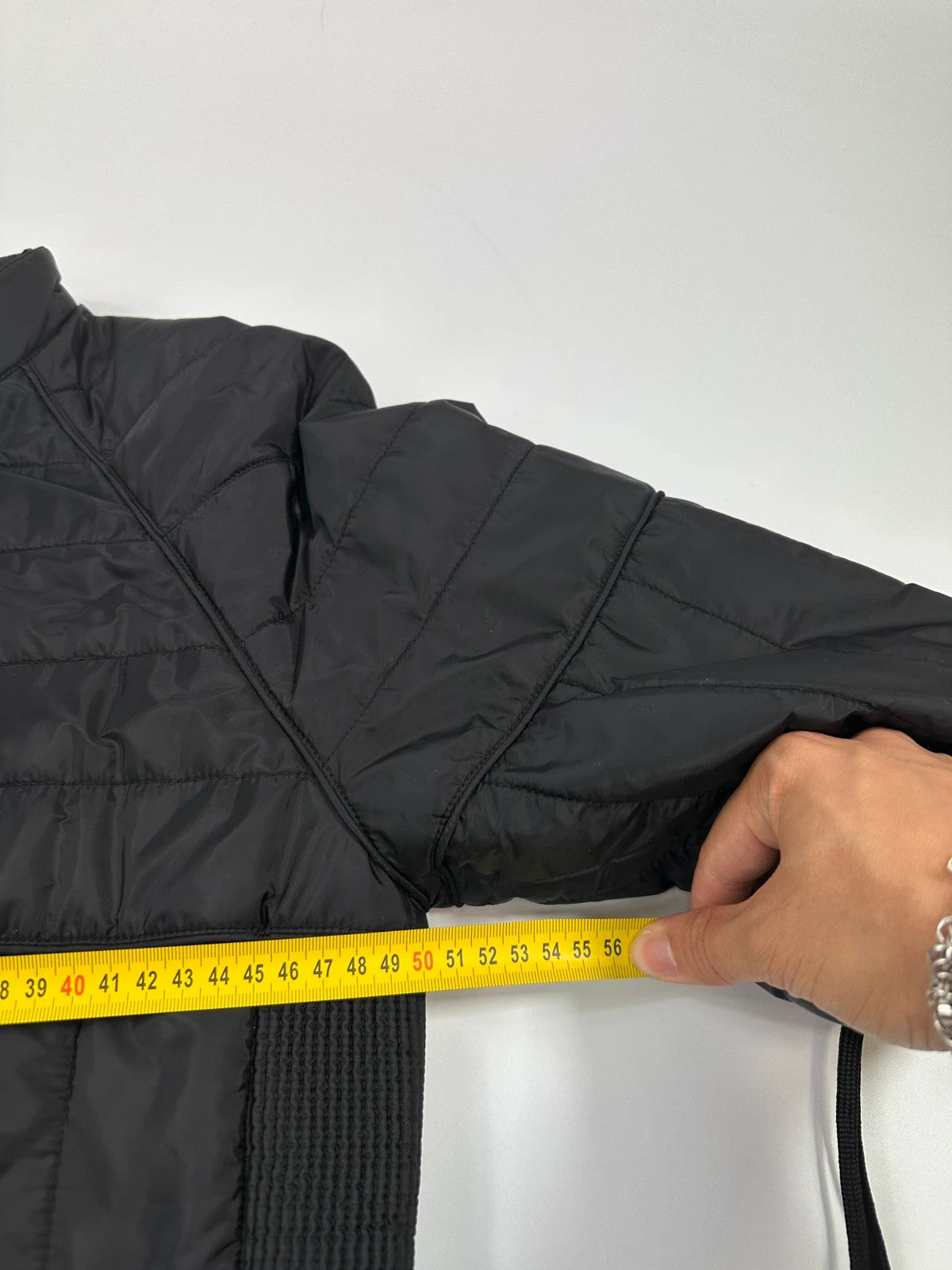 Prada black padded quilted nylon jacket with ribbed side panels and logo detailing.