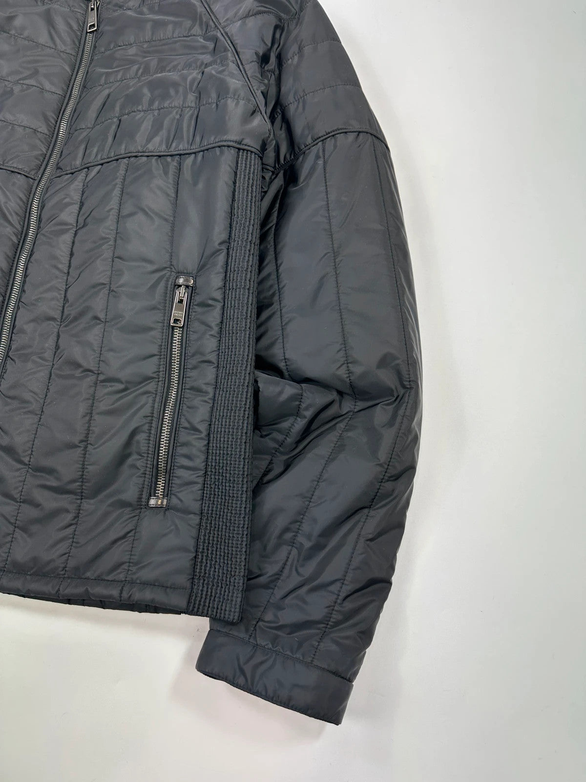 Prada black padded quilted nylon jacket with ribbed side panels and logo detailing.