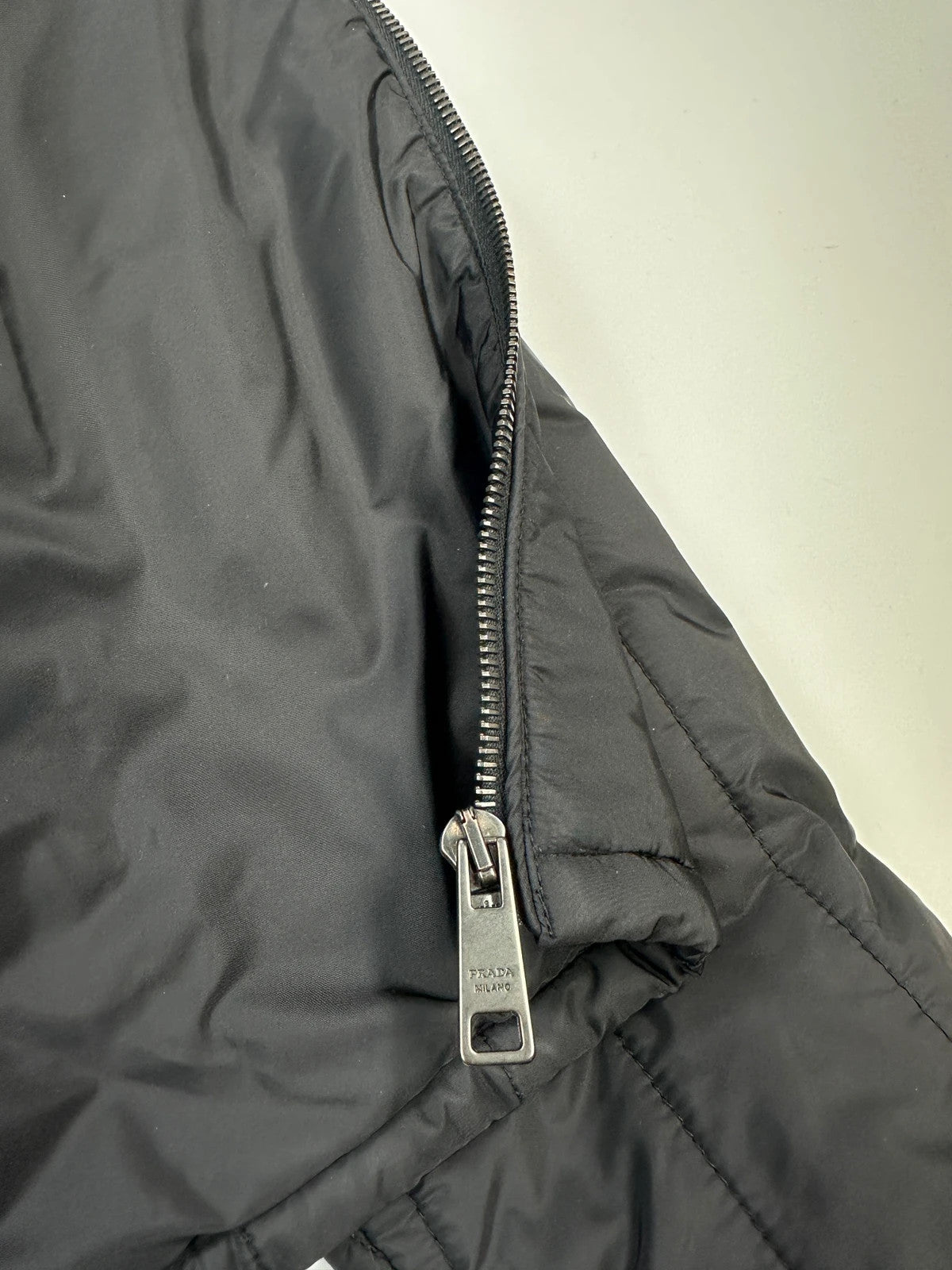 Prada black padded quilted nylon jacket with ribbed side panels and logo detailing.