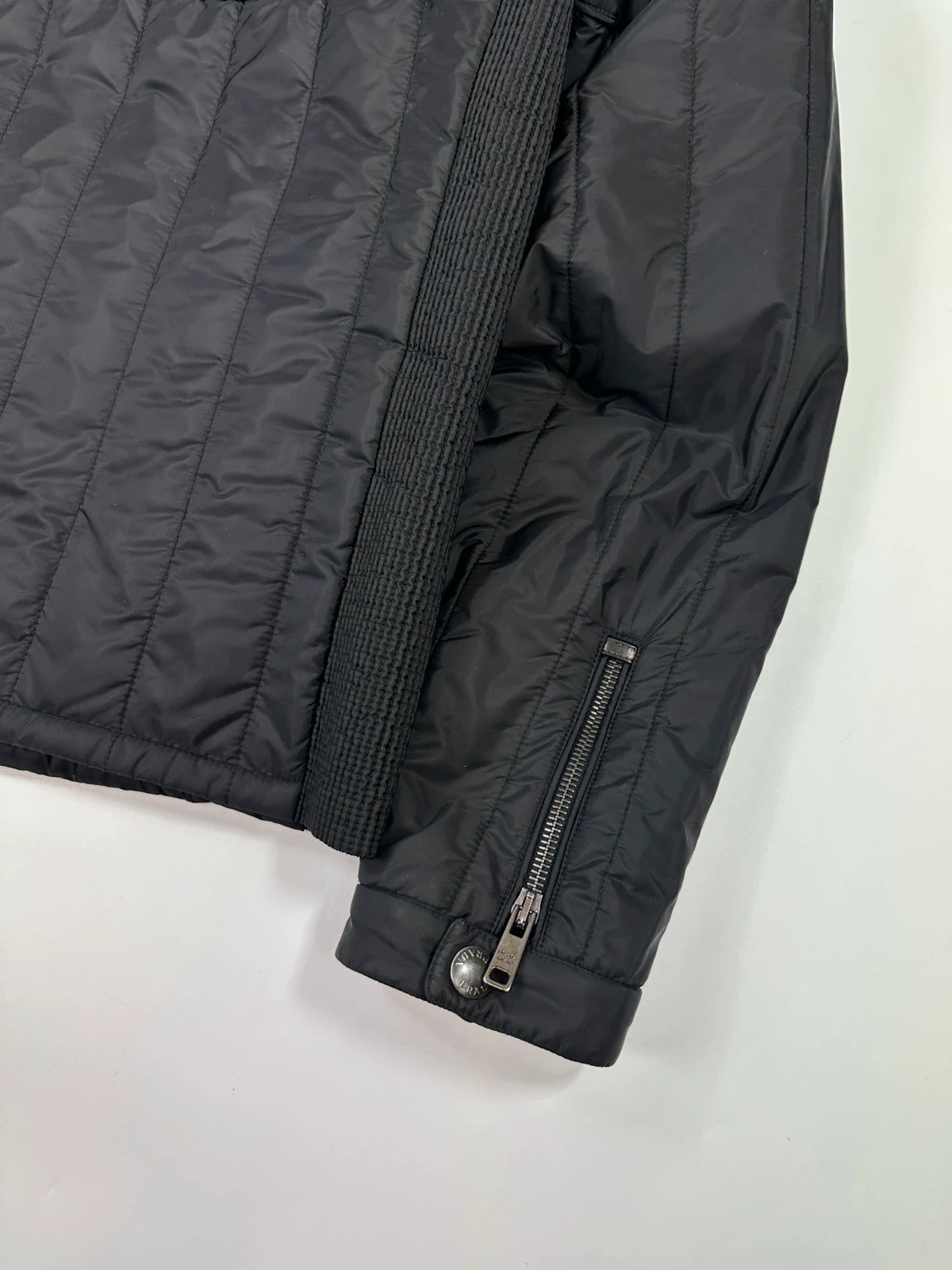 Prada black padded quilted nylon jacket with ribbed side panels and logo detailing.