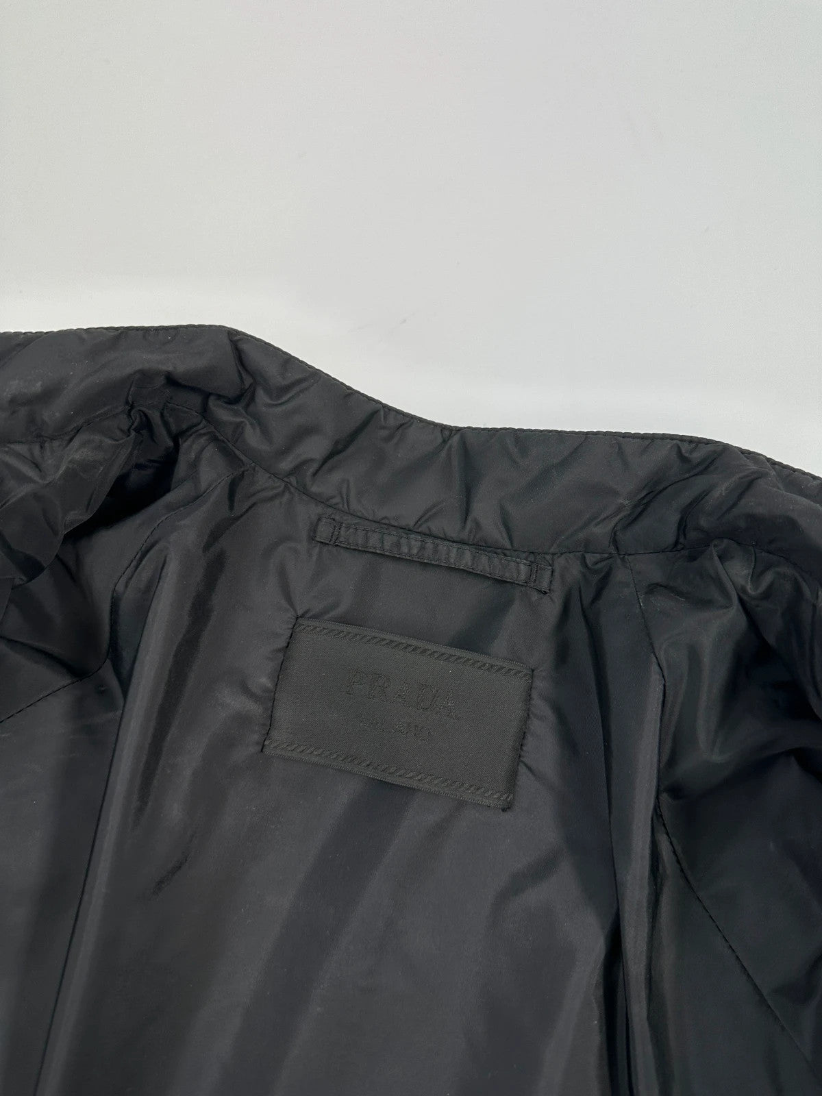 Prada black padded quilted nylon jacket with ribbed side panels and logo detailing.