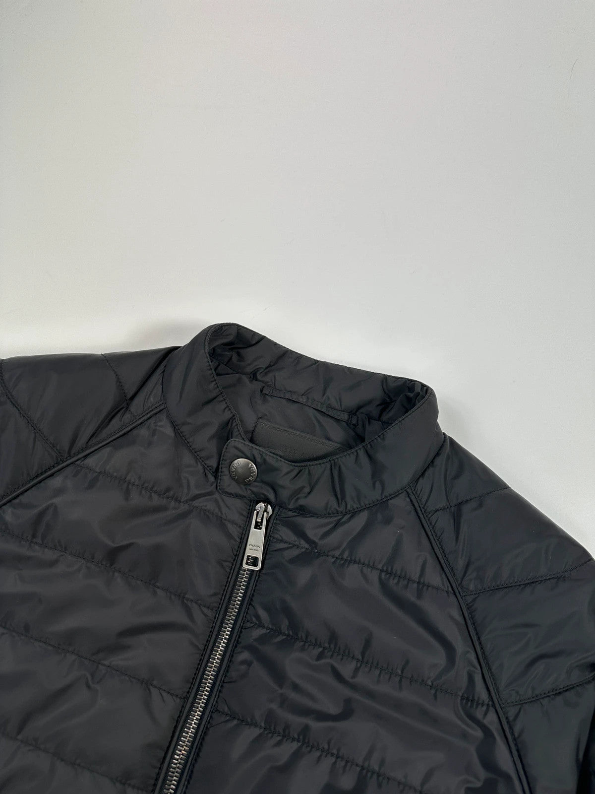 Prada black padded quilted nylon jacket with ribbed side panels and logo detailing.