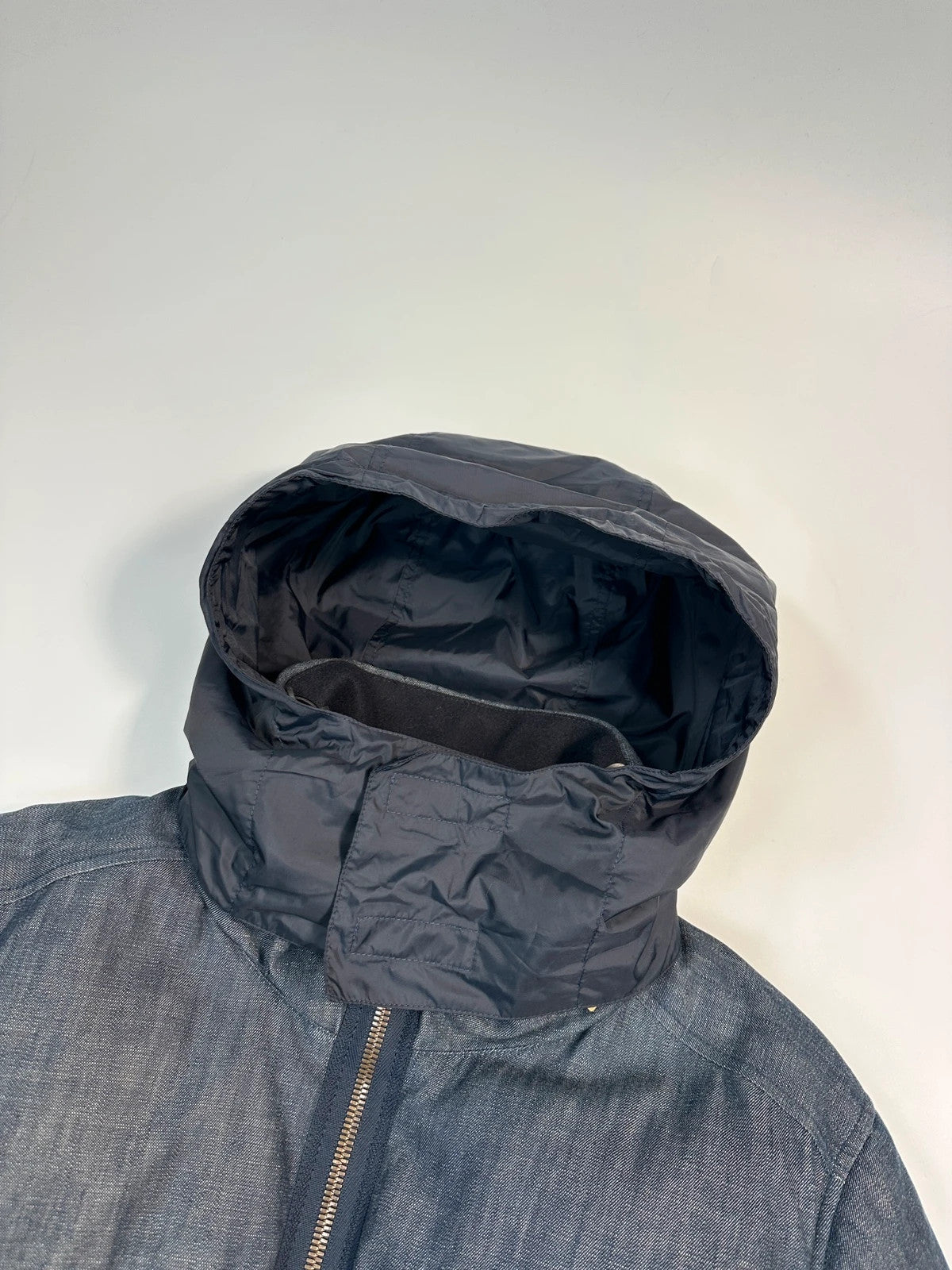 Prada blue hybrid down puffer jacket with removable hood and denim material.