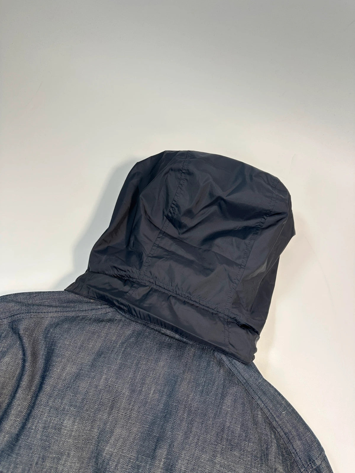 Prada blue hybrid down puffer jacket with removable hood and denim material.