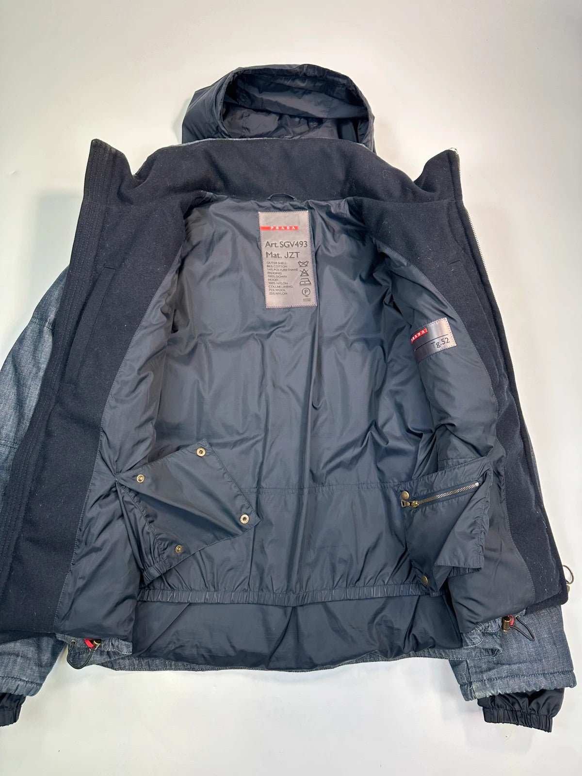 Prada blue hybrid down puffer jacket with removable hood and denim material.