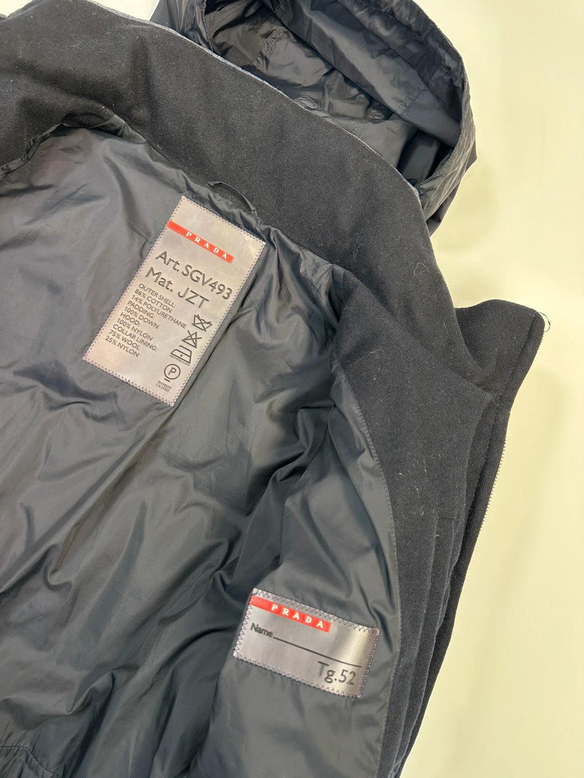 Prada blue hybrid down puffer jacket with removable hood and denim material.