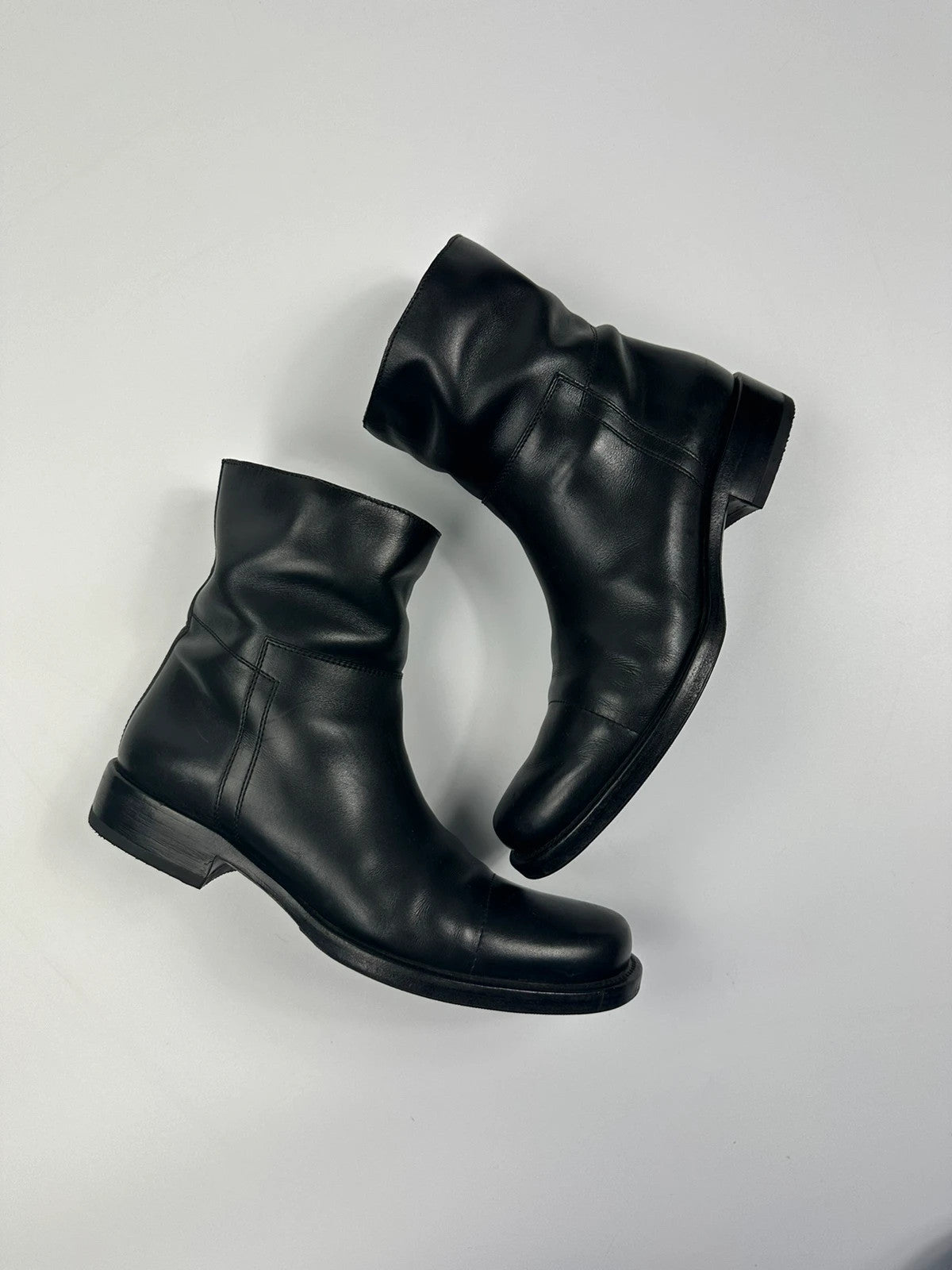 Prada black leather ankle boots with round toe and subtle logo detailing.