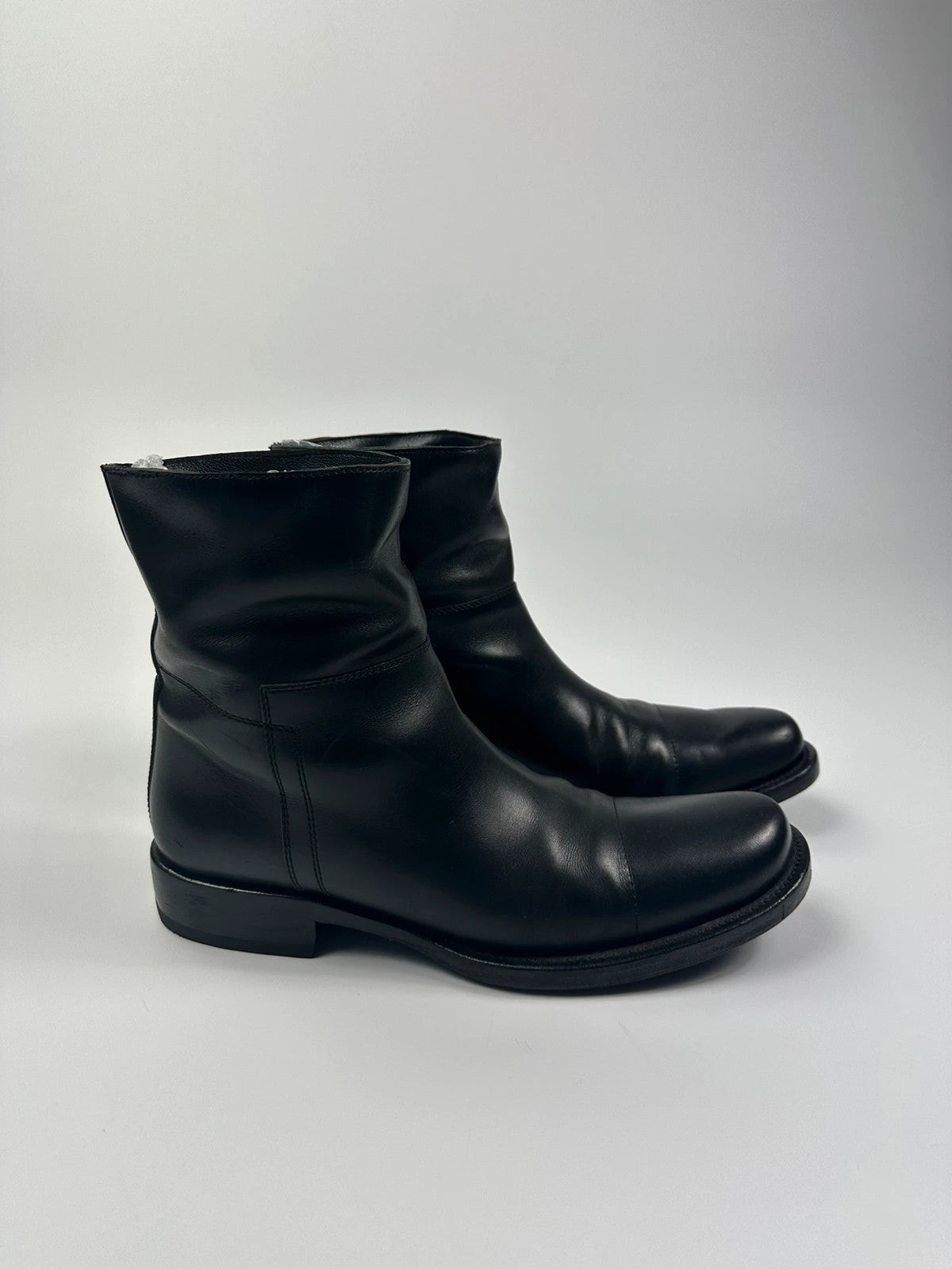 Prada black leather ankle boots with round toe and subtle logo detailing.