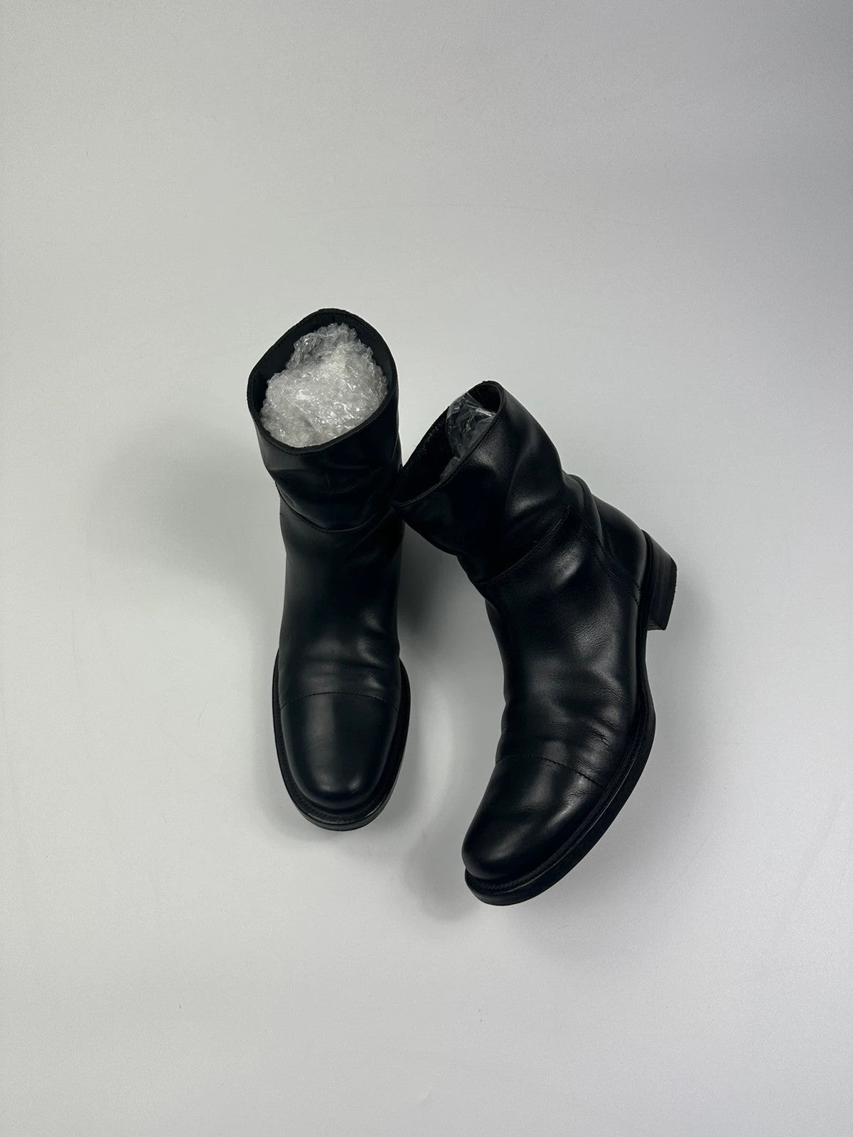 Prada black leather ankle boots with round toe and subtle logo detailing.