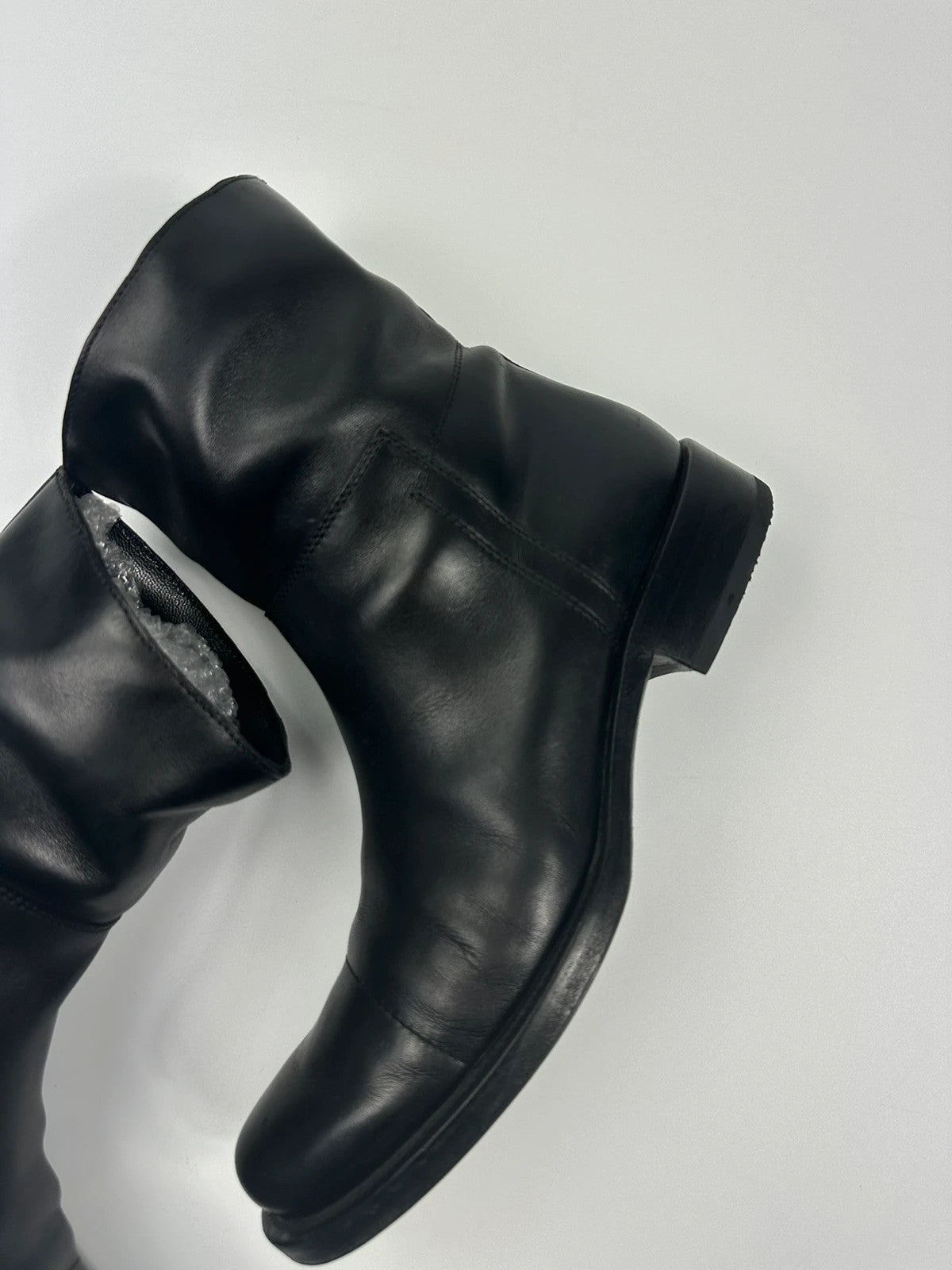 Prada black leather ankle boots with round toe and subtle logo detailing.