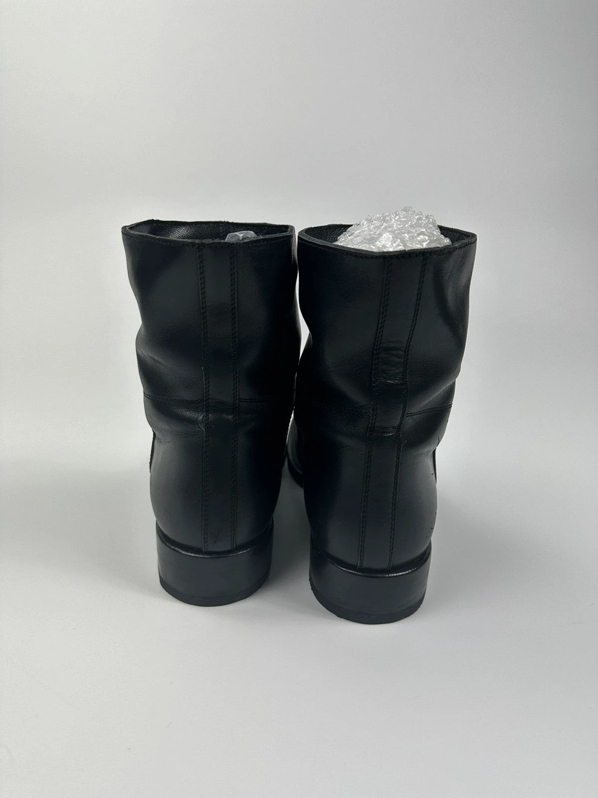 Prada black leather ankle boots with round toe and subtle logo detailing.