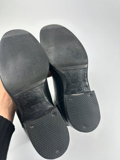 Prada black leather ankle boots with round toe and subtle logo detailing.