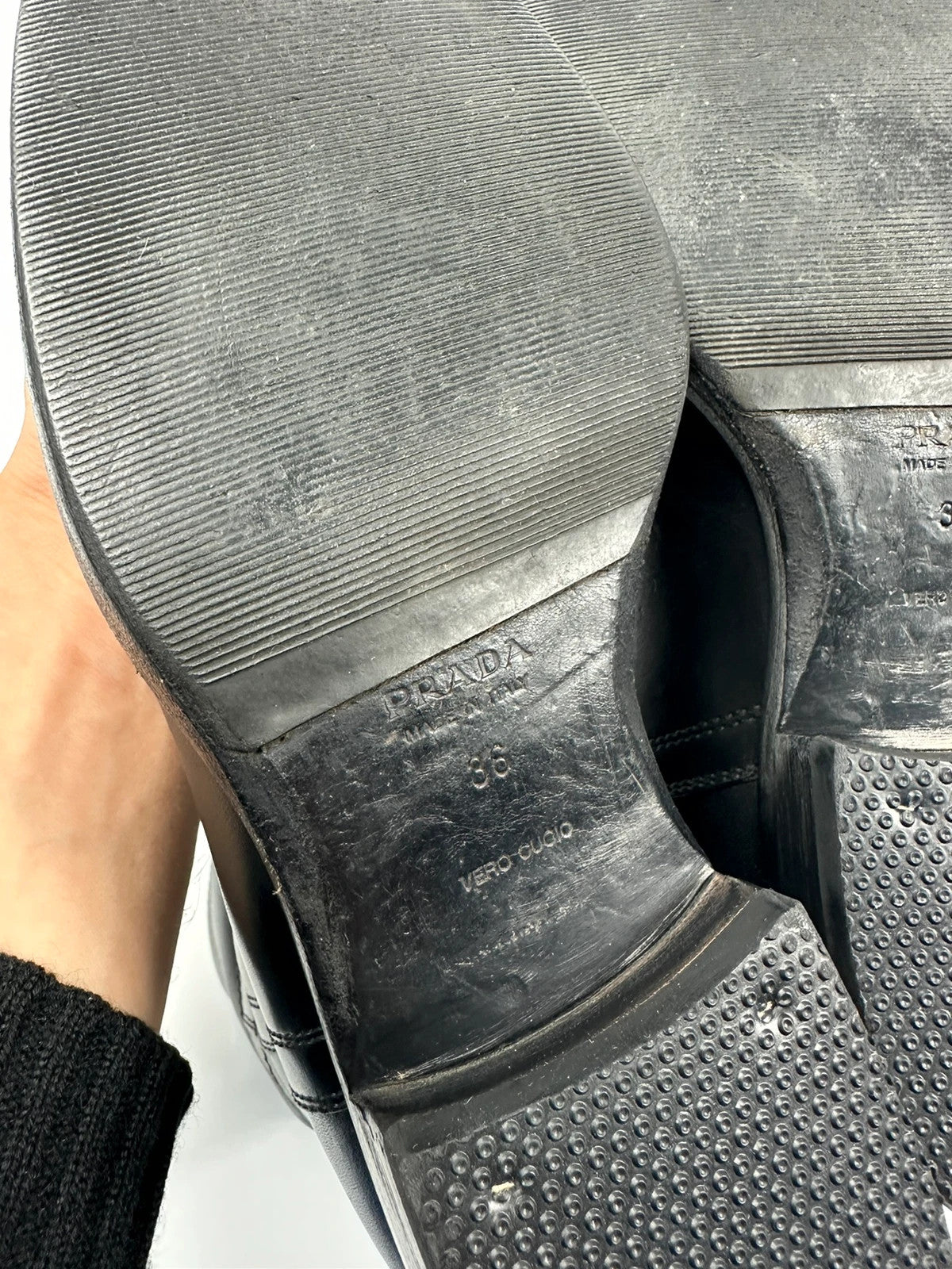 Prada black leather ankle boots with round toe and subtle logo detailing.