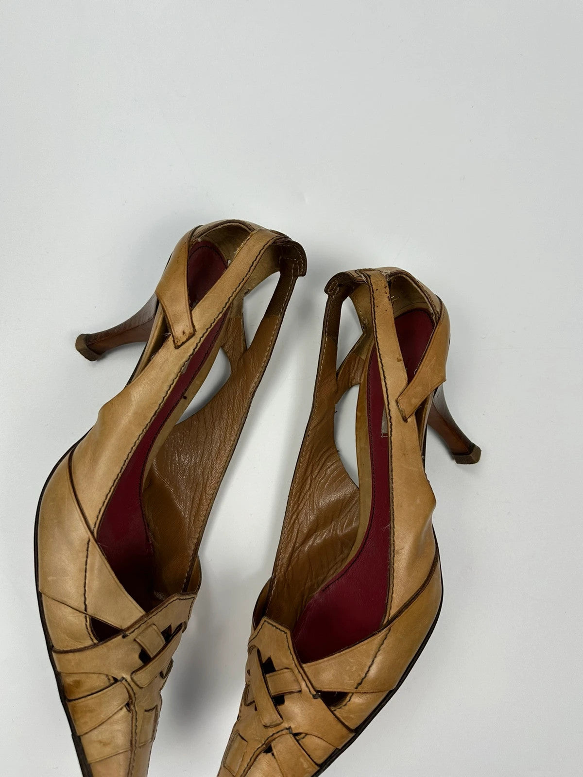 Prada beige leather pumps with pointy toe and subtle logo detailing.
