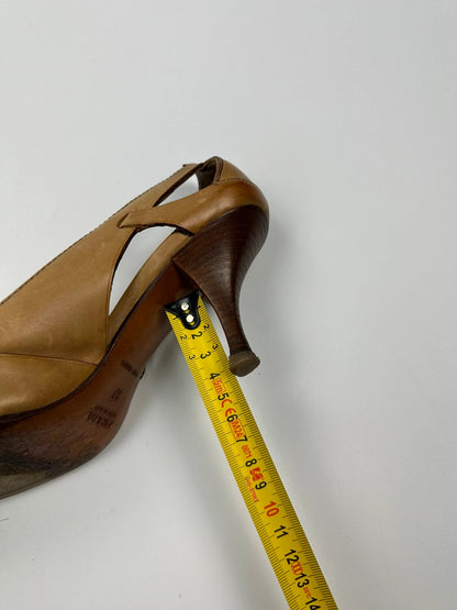 Prada beige leather pumps with pointy toe and subtle logo detailing.
