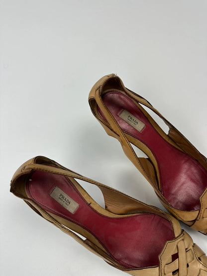 Prada beige leather pumps with pointy toe and subtle logo detailing.