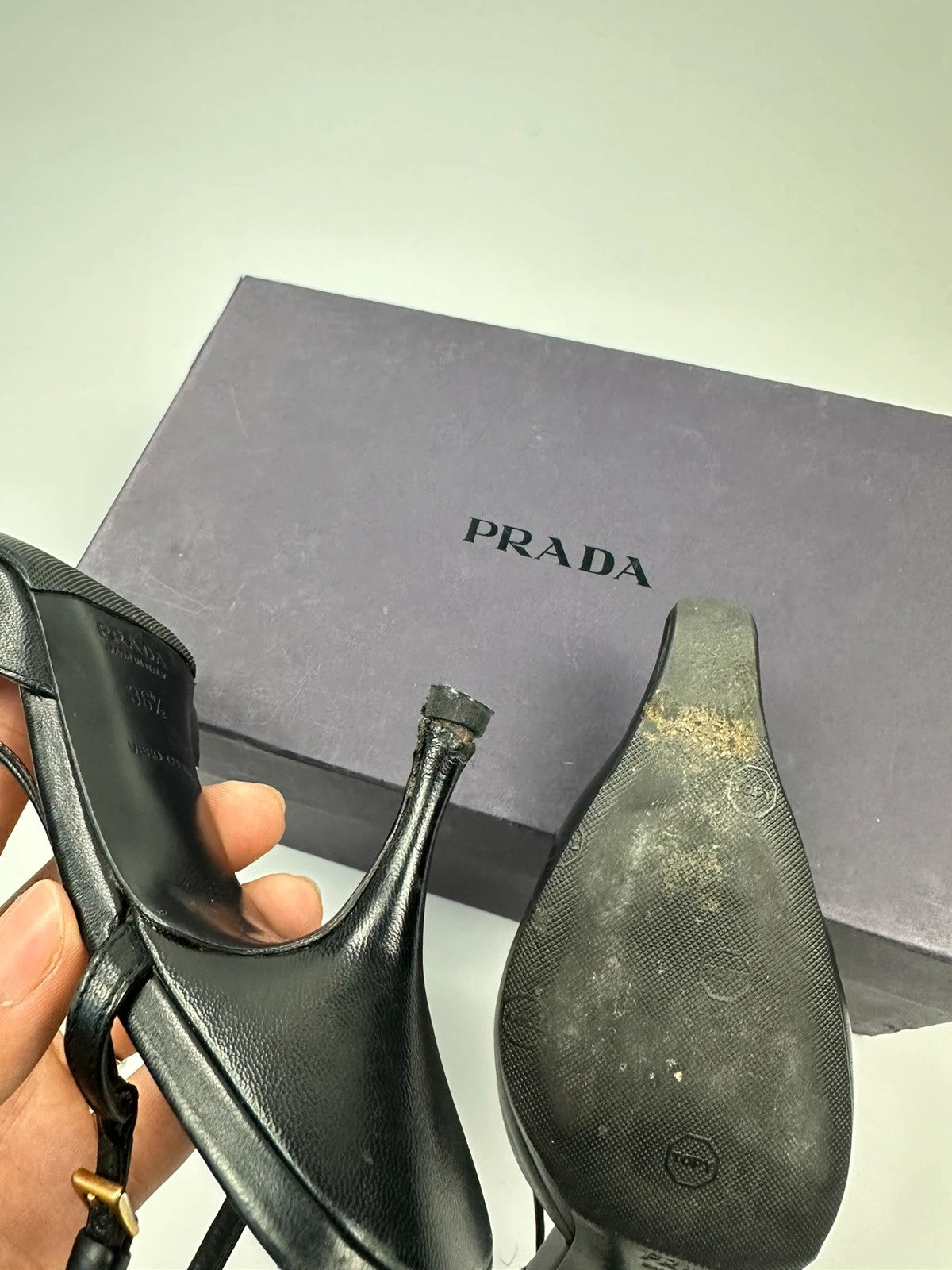 Prada black leather slingback mules with minimalist design and logo detail.