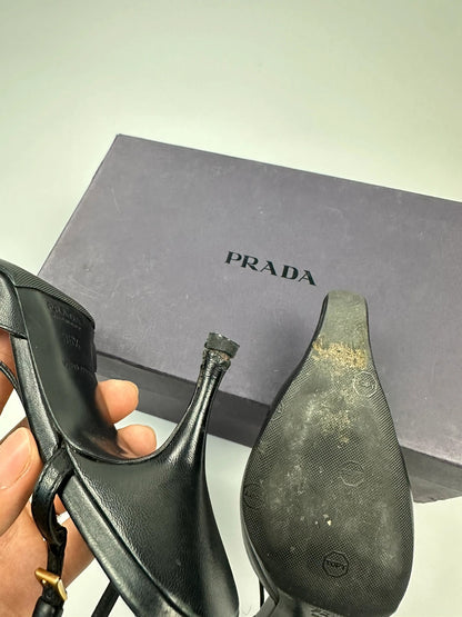 Prada black leather slingback mules with minimalist design and logo detail.
