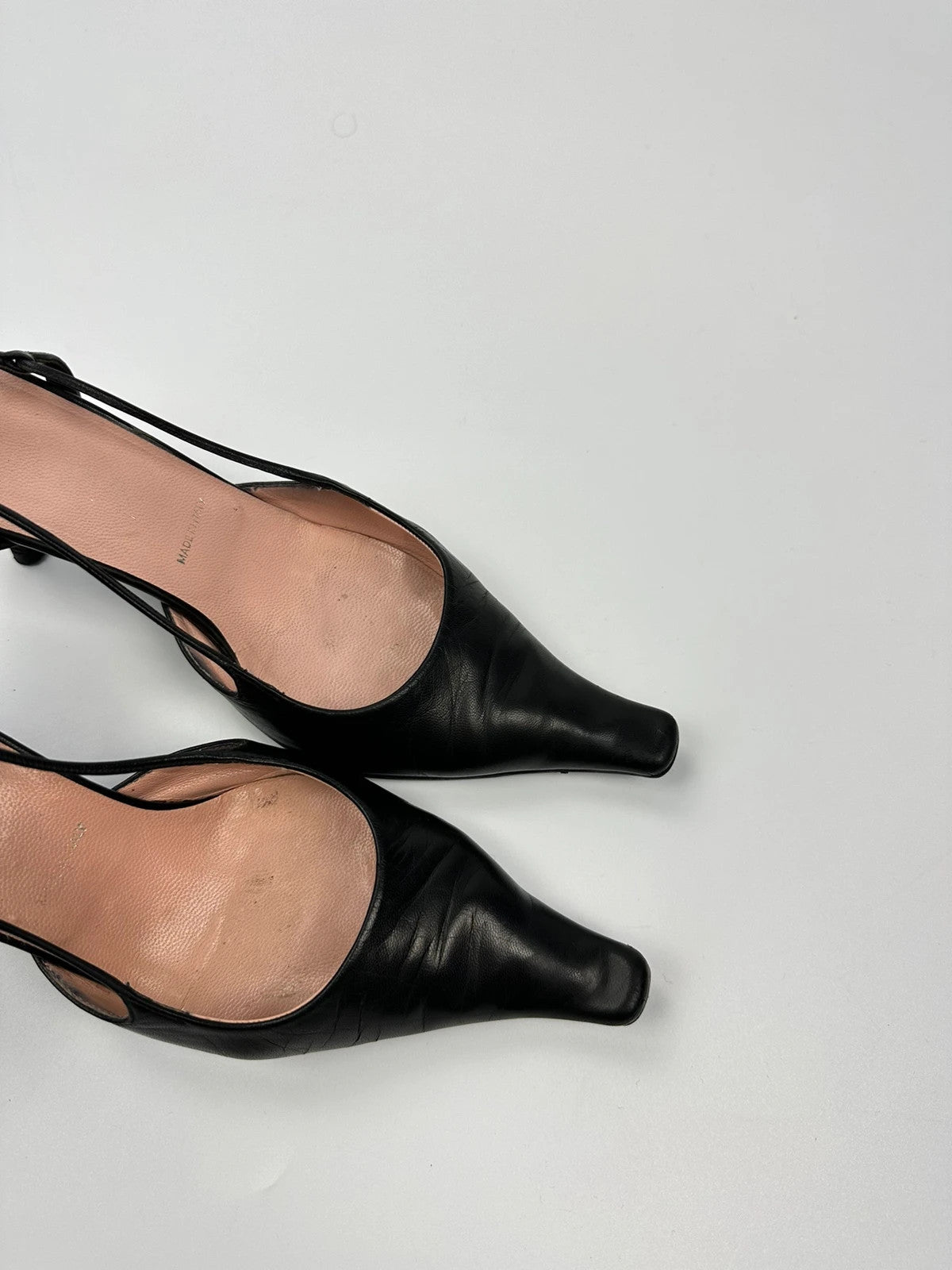 Prada black leather slingback mules with minimalist design and logo detail.